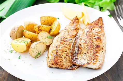 Plato de pescado a la plancha servido con una generosa porción de mayonesa de alcaparras