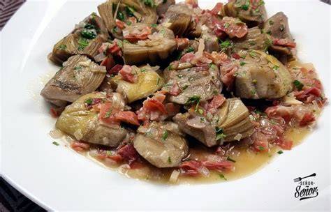 Plato de alcachofas con calabaza servido en una mesa rústica