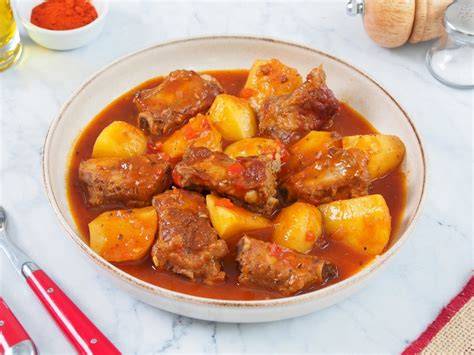 plato de costillas en salsa con patatas