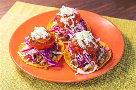 Plato de enchiladas hondureñas con ingredientes frescos