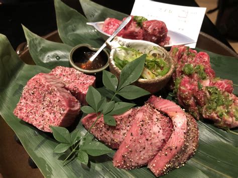 Plato de yakiniku con diferentes cortes de carne y salsa