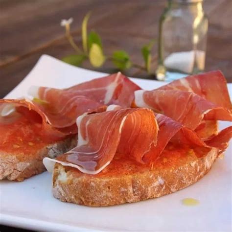 Imagen de una tostada de jamón con tomate y aceite de oliva