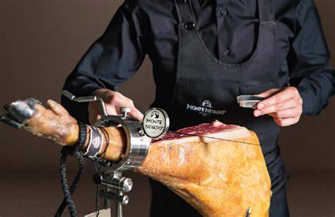cortador de jamón profesional realizando un corte en directo durante un evento