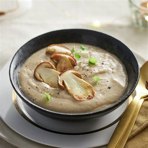 crema de hongos servida en un bol elegante con decoración de setas