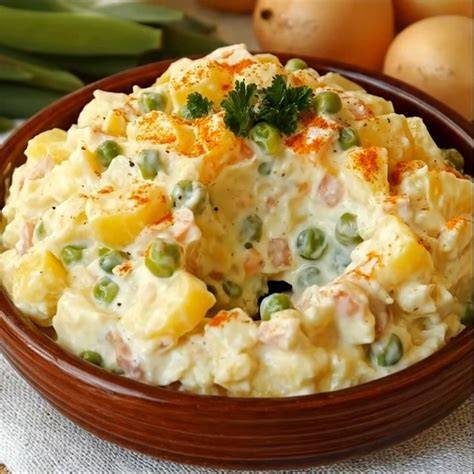 Ensaladilla rusa tradicional con patatas, zanahorias, guisantes, atún y mayonesa.