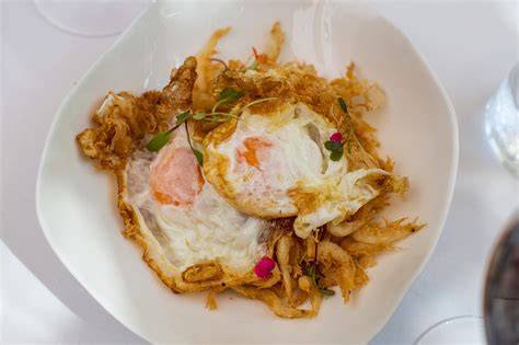 Plato de gambas de cristal fritas con huevo servido en mesa