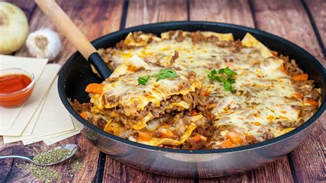 Lasaña cocinándose en una sartén con tapa
