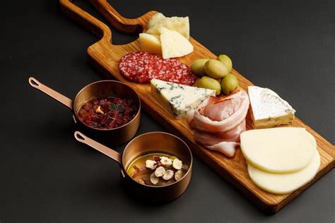 Tabla de quesos y embutidos con diferentes salsas