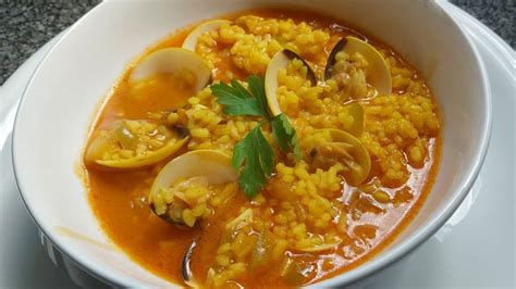 Plato de arroz caldoso con bacalao y almejas recién servido