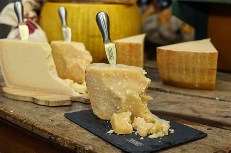 ruedas de queso Parmigiano Reggiano en estantes de maduración
