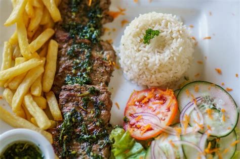 Plato servido de churrasco de ternera con chimichurri y guarnición