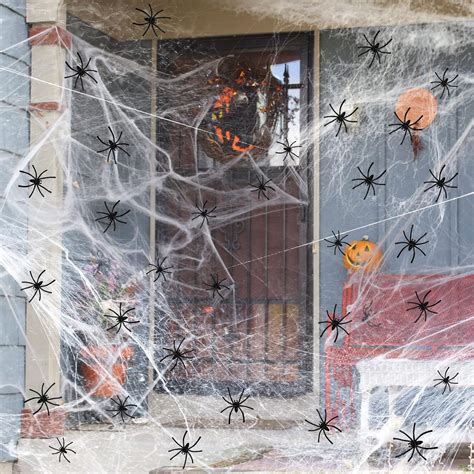 Puerta de Halloween decorada con calabazas, telarañas y arañas