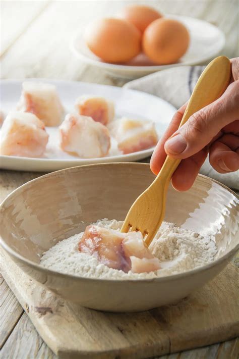 Proceso de rebozado: pescado pasando primero por harina y luego por huevo batido