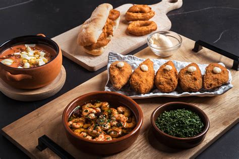 Variedad de tapas españolas, incluyendo croquetas, para un aperitivo completo