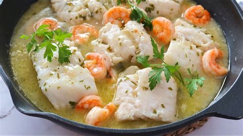 Merluza y gambas a la plancha en una sartén