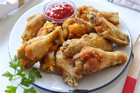 Alitas de pollo fritas servidas con salsa