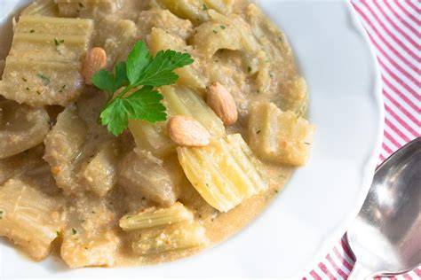 Imagen de un plato de cardo con almendras decorado con piñones