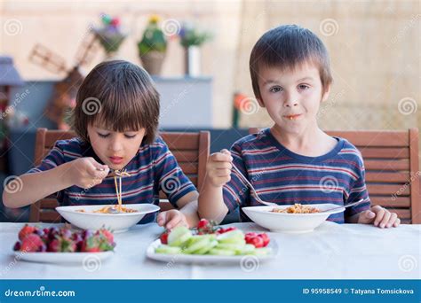 Niños comiendo espaguetis a los 4 quesos