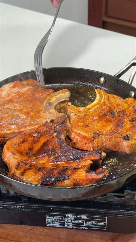 Chuletas de cerdo doradas en sartén con cebolla pochando