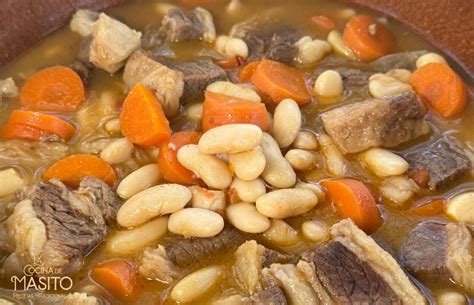 Plato de fabes pintes con costilla servido en un cuenco de barro tradicional