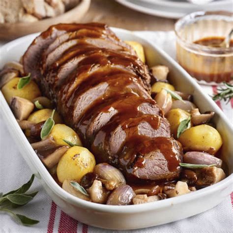 Plato servido con redondo de ternera relleno, patatas asadas y salsa