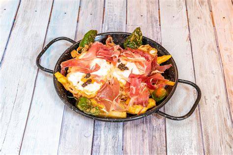 Plato de huevos rotos con patatas y pimientos