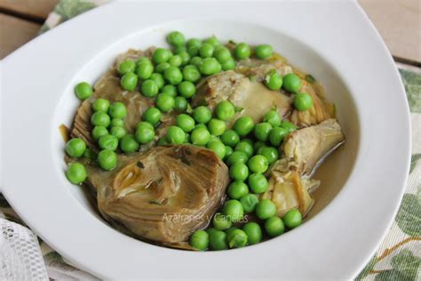 Guiso de guisantes con alcachofas y jamón hirviendo en una cazuela