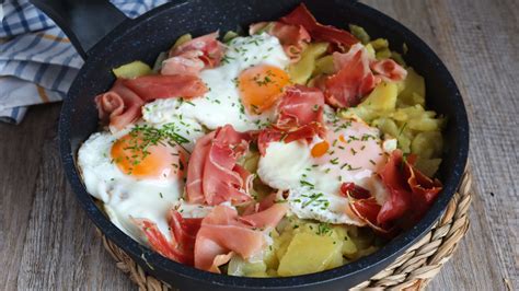Huevos rotos con yema líquida sobre patatas y setas