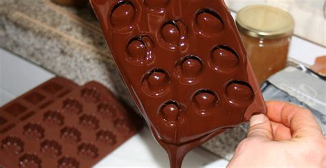 Proceso de llenado de moldes de chocolate