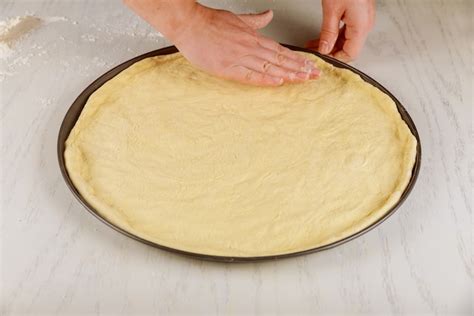 Masa de pizza estirada en una bandeja