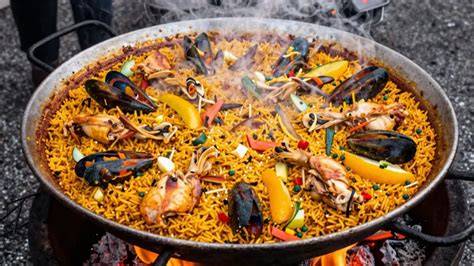 Paella gigante cocinándose a la leña