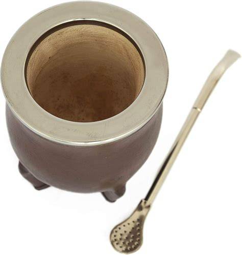 Taza de mate tostado humeante con yerba mate a su lado