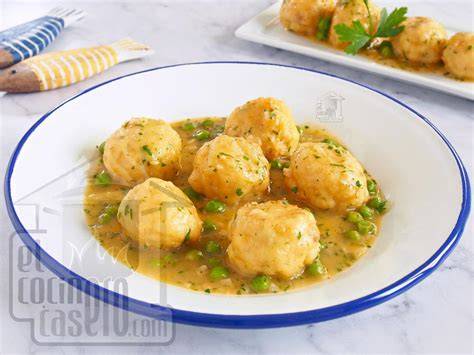 Plato de albóndigas de merluza en salsa verde servido en una mesa