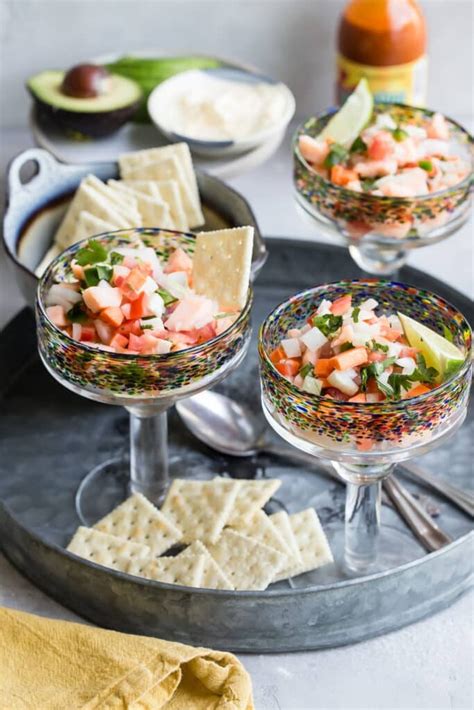 Plato de ceviche de salmón, aguacate y gambas servido en copa