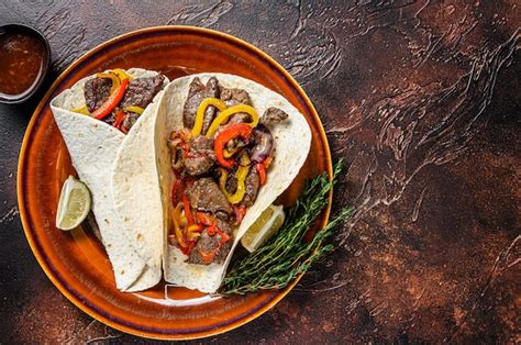Foto de fajitas de res servidas con tortillas y acompañamientos
