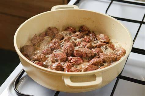 Carne de res cocinándose en una olla grande