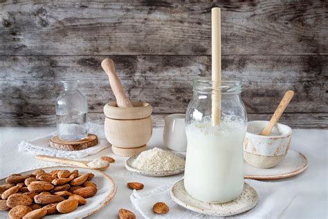 Imagen de una jarra de leche vegetal casera junto a granos de espelta