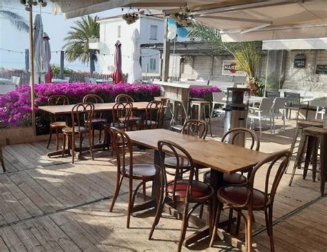 Terraza de Olla Beach Bar al atardecer con música en vivo