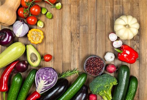 Ingredientes frescos sobre una mesa de cocina: alubias, verduras, especias y codornices