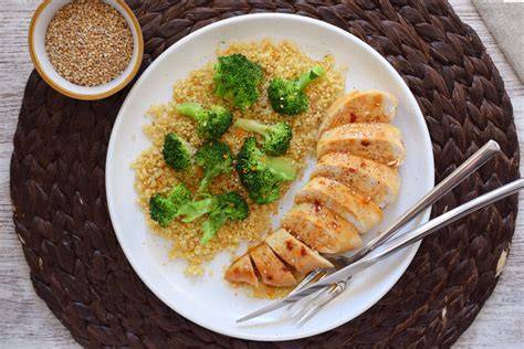 Plato servido de pollo a la miel con crema de aguacate y quinoa