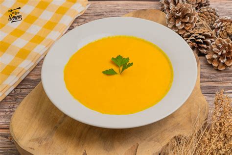 Plato de crema de calabaza decorado con taquitos de calabaza y especias