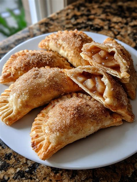 Bandeja de empanadillas de manzana recién horneadas y espolvoreadas con canela
