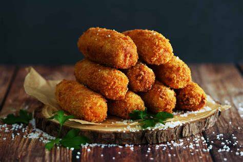 Croquetas caseras recién fritas con salsa de acompañamiento