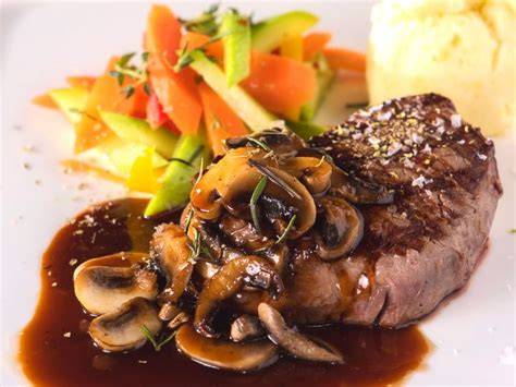 Medallones de carne de res con salsa de champiñones servidos en un plato elegante