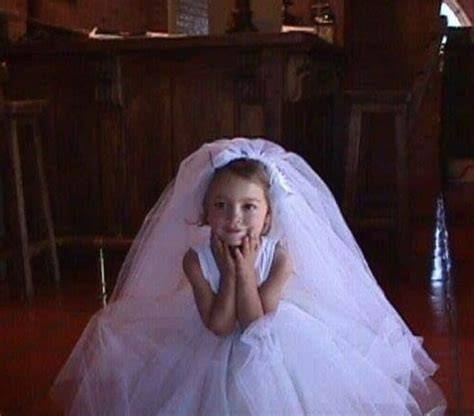 Niños jugando a casarse, con una niña vestida de novia