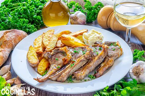 Chuletas de cordero al horno servidas con patatas y ensalada