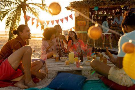 Grupo de personas disfrutando de una moraga en la playa al atardecer