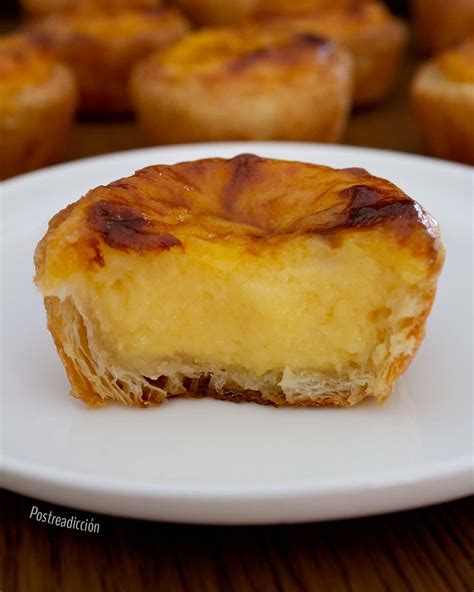 Pasteles de nata recién horneados con azúcar glas y canela