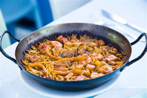 Fideuá terminada en la paella saliendo del horno