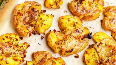 Plato de patatas aplastadas al horno con especias y hierbas frescas